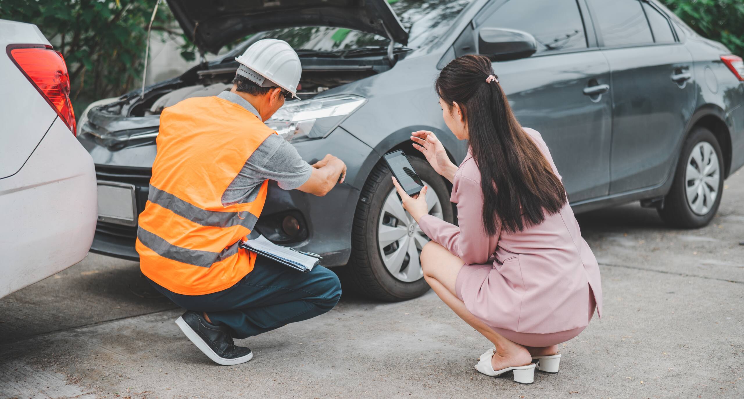 An insurance adjuster inspecting vehicle damage after a rear-end accident on I-90 in Spokane to look for evidence to blame the lead driver.