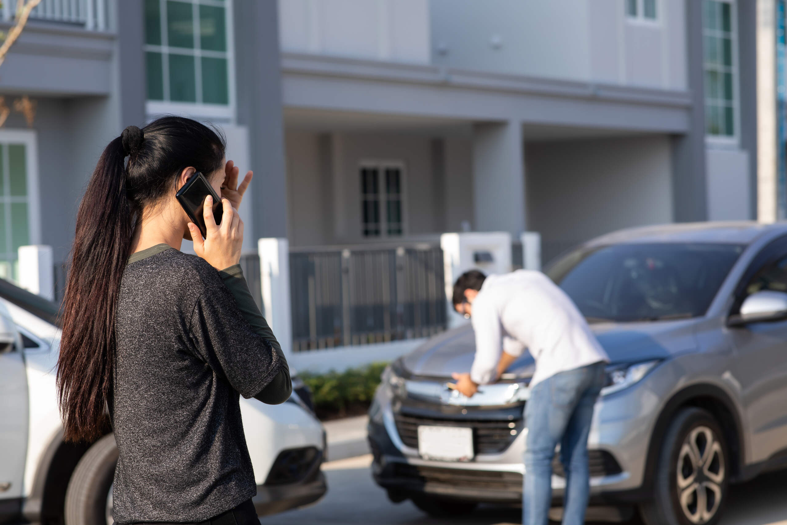 A driver on the phone at a Spokane crash scene, illustrating the risk of insurance companies using sudden stop defenses to shift blame after being rear-ended on I-90.