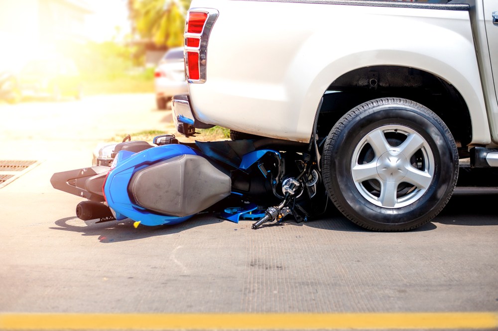 Motorcycle lodged under a truck after a collision, the type of crash insurers may wrongly blame on the rider